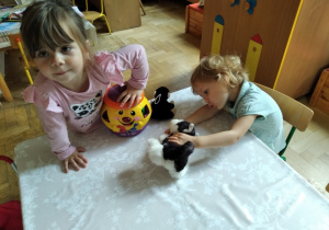 Dziewczynki bawią się przy stoliku.